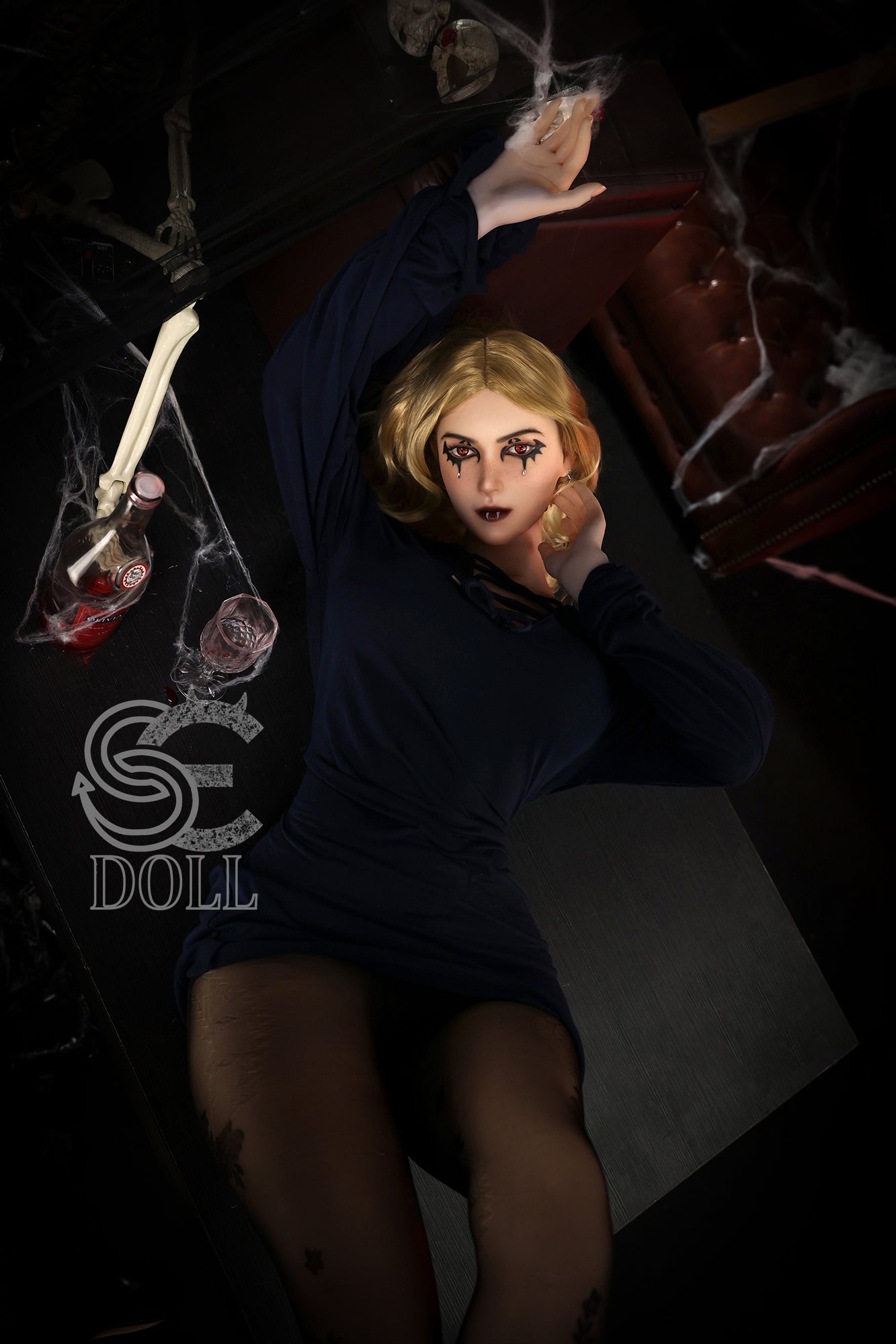 Blonde adult doll with exotic facial makeup and full breasts.