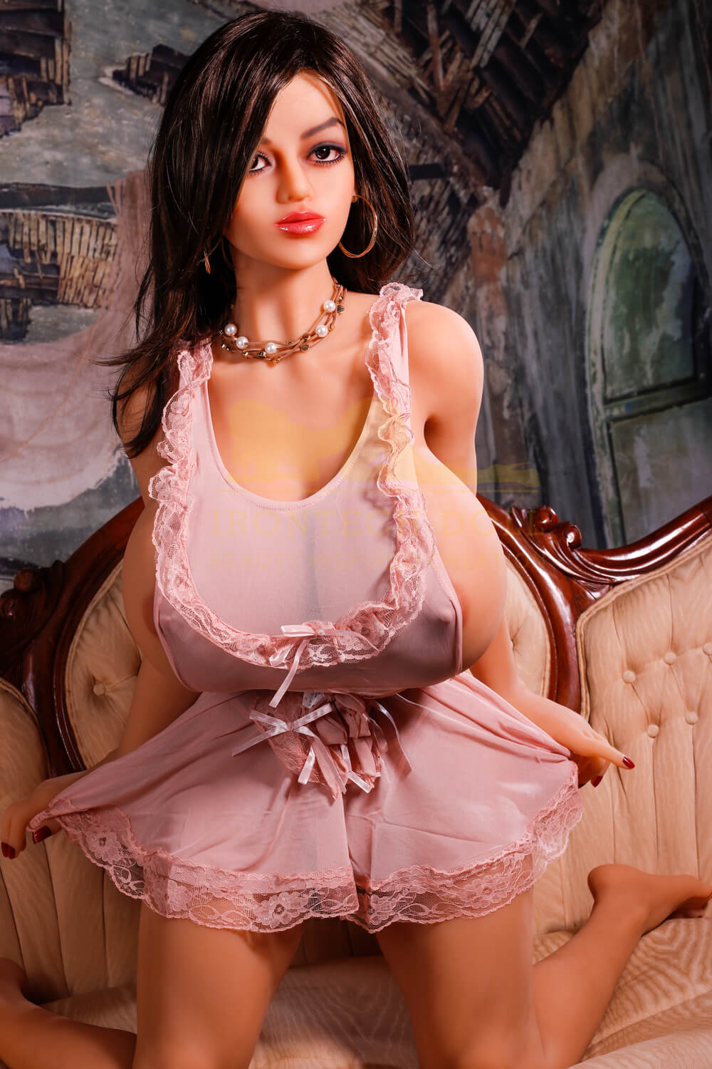 Realistic TPE sex doll with long brown hair, large breasts, and pink lingerie.